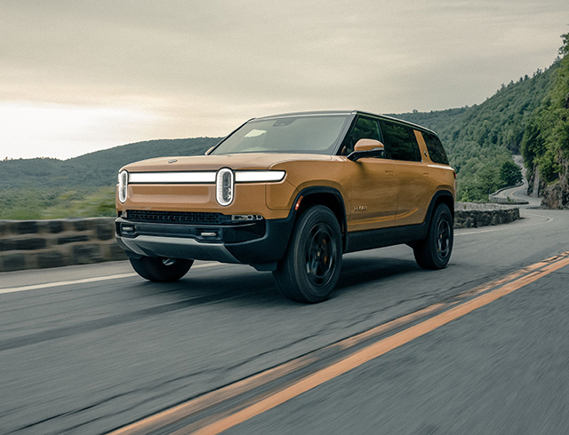 Rivian R1s driving on an intersection