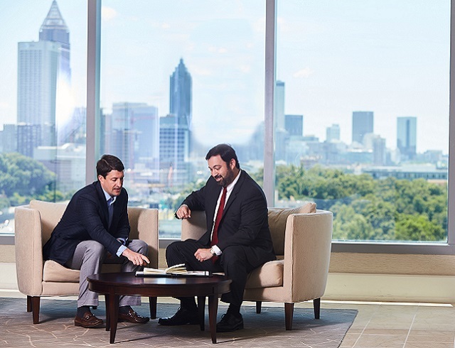 Two men sitting and talking about a document in front of them on a table